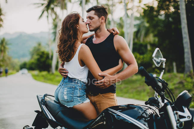 Romantica giovane coppia che si abbraccia in moto su strada rurale, Krabi, Thailandia — Foto stock