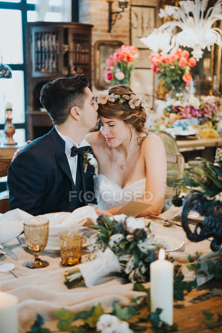 Bride and bridegroom at table at wedding reception — Stock Photo