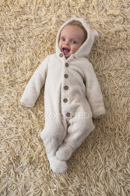Overhead portrait of cute baby boy in furry babygro — Stock Photo