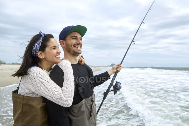 Retrato de pareja joven pescando en el mar - foto de stock