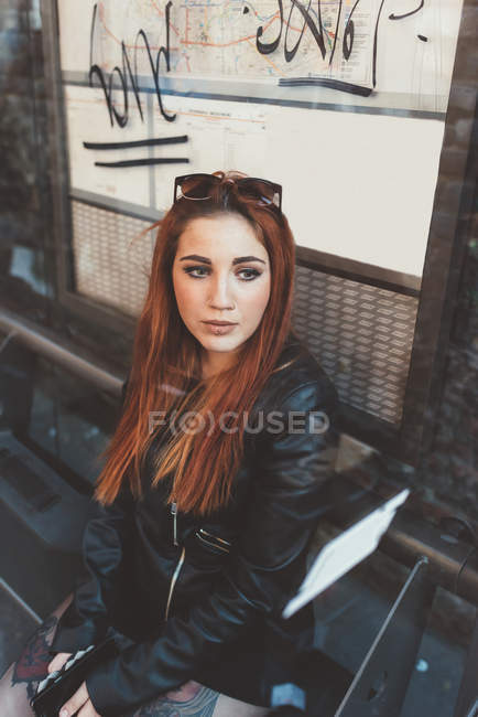 Red haired woman waiting at bus stop — Stock Photo