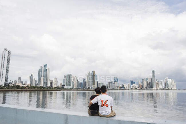 Vue arrière du couple assis au bord de l'eau, Panama City, Panama, Panama — Photo de stock