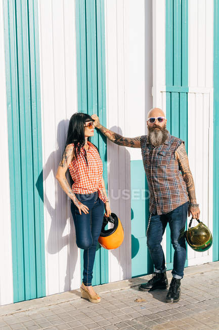Coppia di hipster maturi appoggiati alla parete a strisce, ritratto — Foto stock