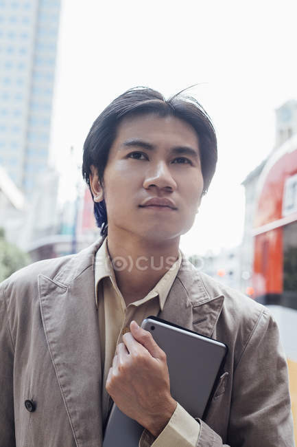 Hombre joven llevando tableta digital al aire libre - foto de stock