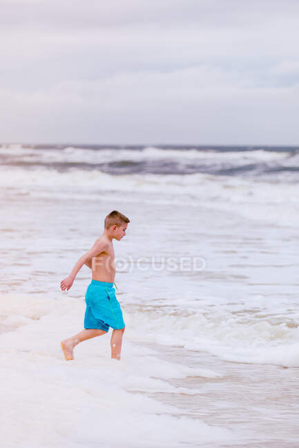 Boy running into sea, Dauphin Island, Alabama, USA — Stock Photo