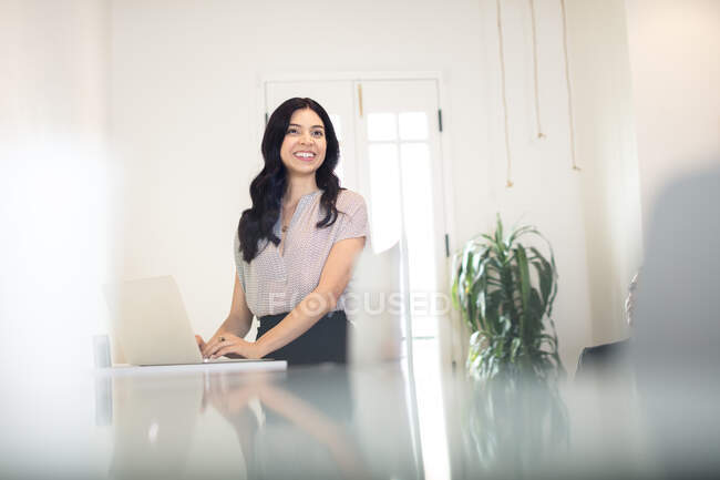 Junge Geschäftsfrau tippt am Schreibtisch auf Laptop — Stockfoto