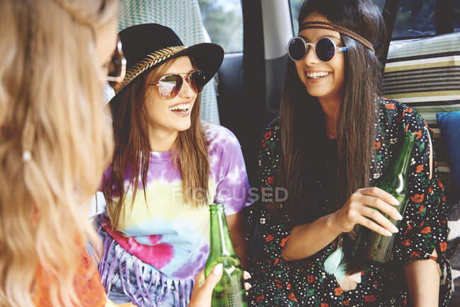 Three young boho women wearing sunglasses in recreational van — Stock Photo
