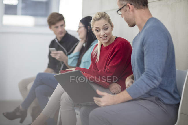 Male and female office workers looking at laptop in meeting — Stock Photo