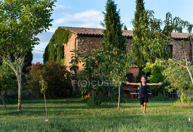 Мальчик играет в саду фермерского дома — стоковое фото