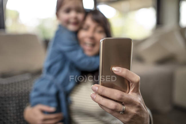 Foco superficial de la mujer madura tomando selfie con hija - foto de stock