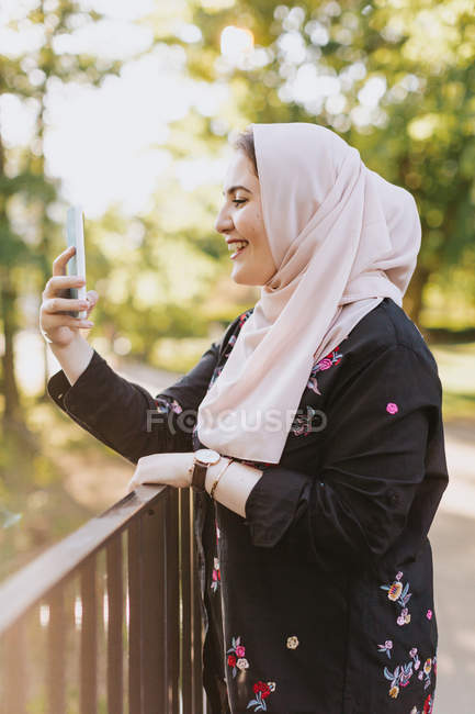 Молода жінка в хіджабі бере селфі на відкритому повітрі — стокове фото