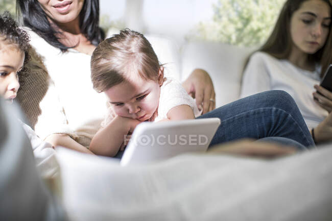 Семья играет с цифровым планшетом на диване — стоковое фото