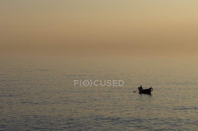 Fisherman on water at sunset, Camogli, Liguria, Italy — Stock Photo