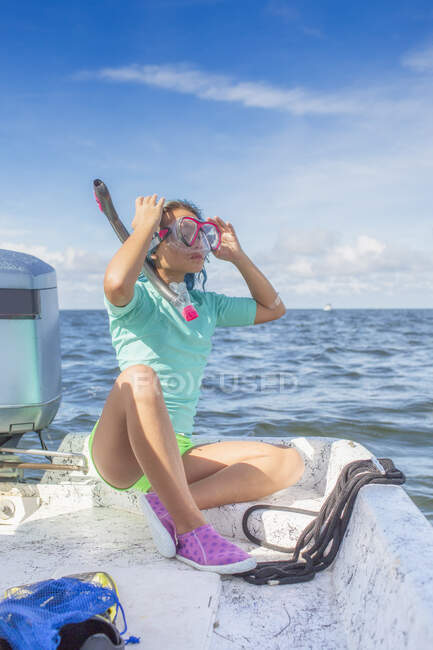 Ragazza montaggio su maschera subacquea sulla barca — Foto stock