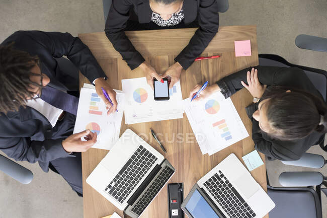 Бізнесмен і бізнес-леді, на офісних зборах, використовуючи ноутбуки, дивлячись на дані, вид зверху — стокове фото