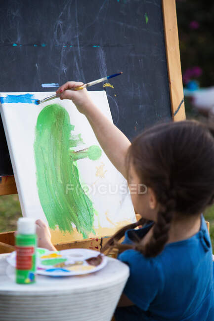 Menina, pintura em tela no jardim — Fotografia de Stock