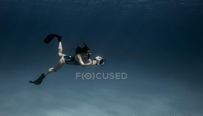 Подводный вид женщины-дайвера с подводной камерой, Бимини, Бахрейн — стоковое фото