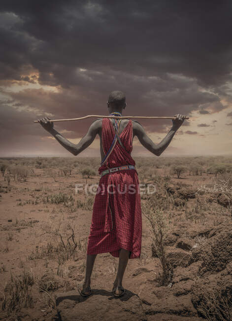 Masai homem com vestido tradicional observando nuvens tempestuosas sobre a savana, Amboseli, Rift Valley, Quênia — Fotografia de Stock