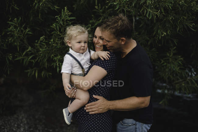 Pregnant couple carrying toddler son — Stock Photo