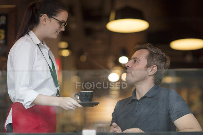 Waitress serving customer coffee — Stock Photo