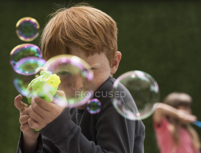 Chico haciendo burbuja fabricante - foto de stock