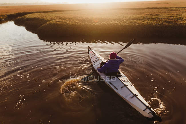 Vue arrière du kayak féminin sur la rivière au coucher du soleil, Morro Bay, Californie, États-Unis — Photo de stock