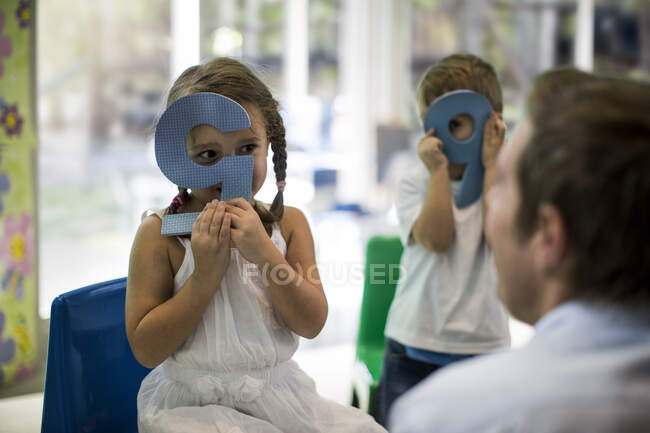 Teacher and children playing with number cutouts — Stock Photo