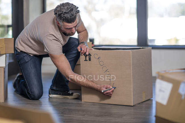 Mann beschriftet Schachtel mit Hausrat — Stockfoto