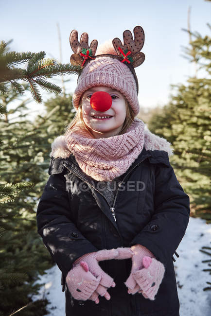 Girl in christmas tree forest with red nose, portrait — Stock Photo