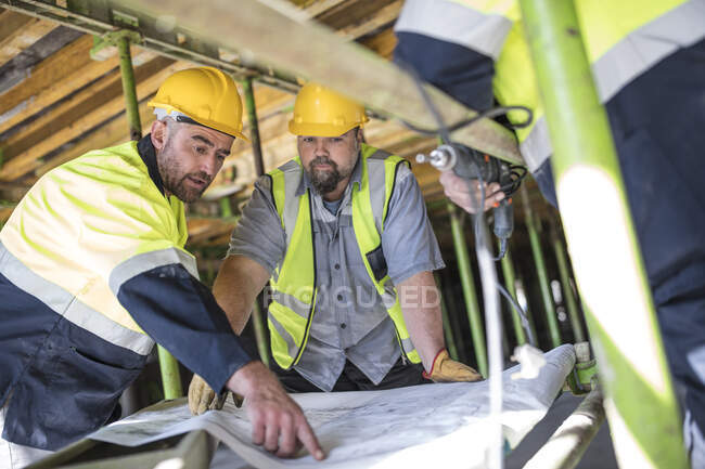 Travailleurs de la construction à la recherche de plans — Photo de stock