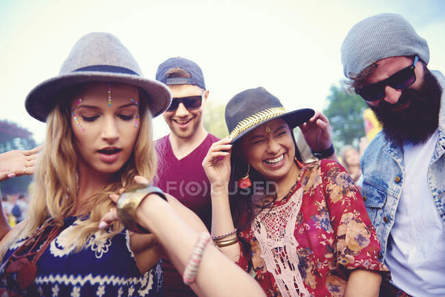 Cuatro amigos adultos jóvenes en fedoras bailando en el festival - foto de stock