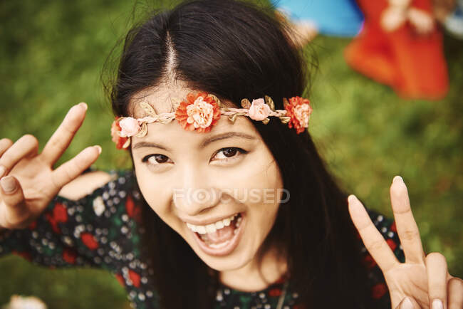 Porträt einer jungen Boho-Frau, die auf dem Festival ein Friedenszeichen setzt — Stockfoto