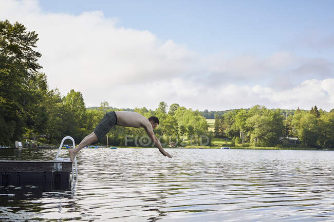 Mature man diving into lake — Stock Photo