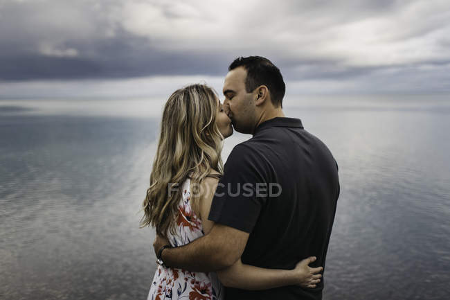 Романтическая пара целуется на воде, Ошава, Канада — стоковое фото