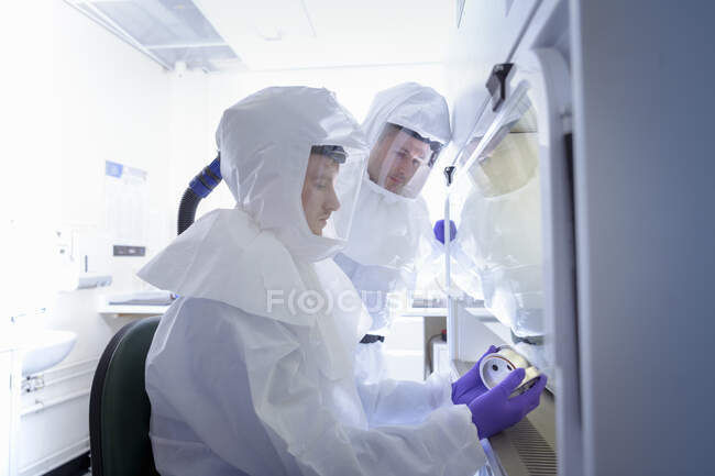 Científicos trabajando en ropa protectora en laboratorio - foto de stock
