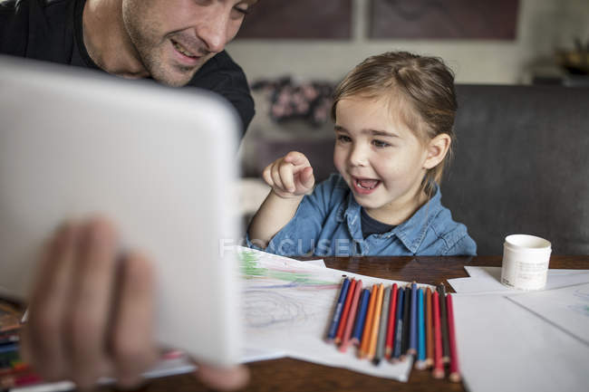 Mann mit Tochter zeigt auf digitales Tablet — Stockfoto