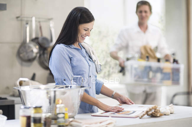 Marido y esposa haciendo preparaciones en la cocina - foto de stock