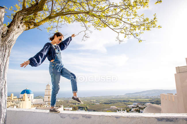 Дівчини на балансування на вершині стіни, Санторіні, Kikladhes, Греція — стокове фото