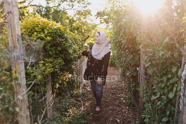 Junge Frau im Hijab bewundert Pflanzen — Stockfoto