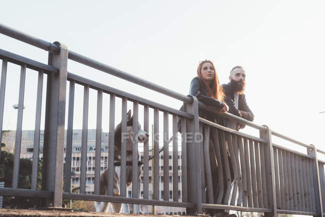 Couple leaning against railings looking away — Stock Photo