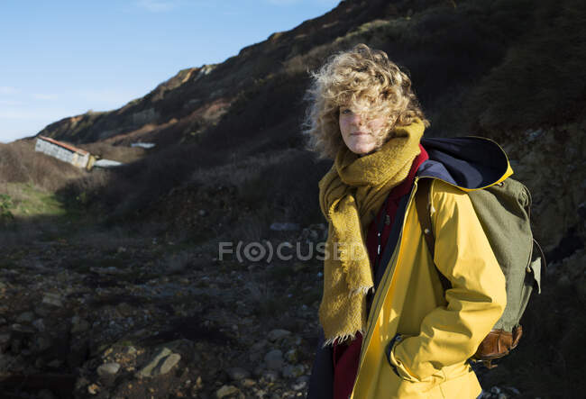 Portrait de fille avec sac à dos rétro randonnée près de l'ancienne station-service de l'OTAN sur la côte normande — Photo de stock