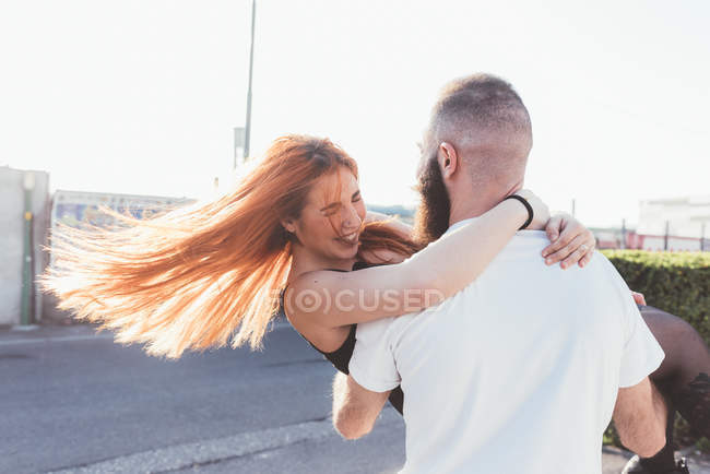Homem carregando mulher sorridente nos braços — Fotografia de Stock