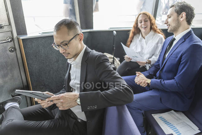 Бізнесмен дивиться на цифровий планшет на пасажирському поромі — стокове фото