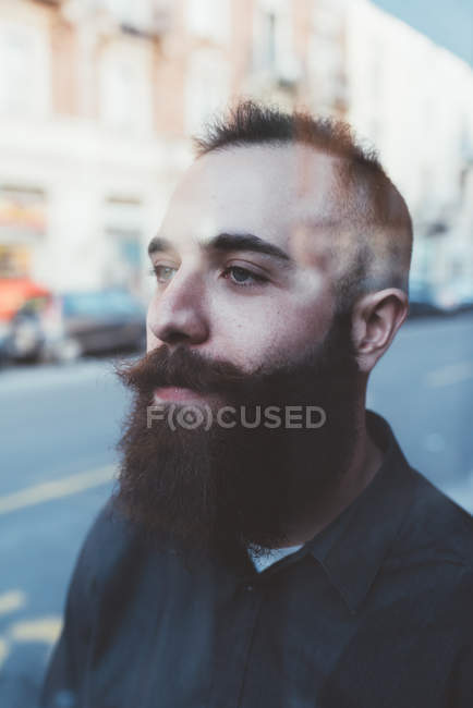 Retrato de un joven barbudo mirando hacia otro lado - foto de stock