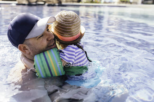 Padre e figlia nella piscina all'aperto, figlia che abbraccia il padre — Foto stock