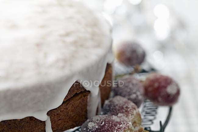 Gâteau glacé sur un stand de gâteau avec des raisins givrés au sucre, gros plan — Photo de stock