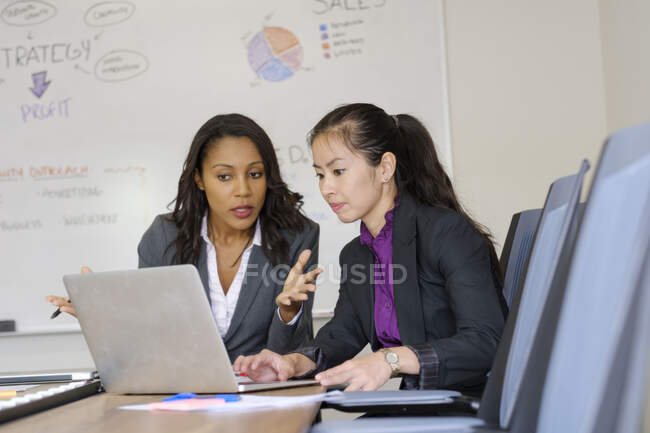 Deux femmes d'affaires au bureau, regardant l'écran d'ordinateur portable — Photo de stock