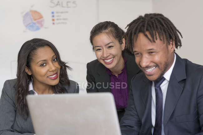 Businessman and businesswomen, in office, looking at laptop — Stock Photo