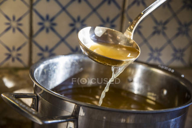 Broth being ladled from saucepan — Stock Photo