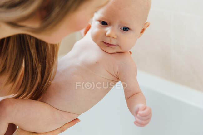 Vista de ángulo alto de baño a bebé de la madre - foto de stock